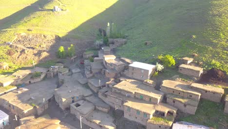 Flight-over-the-rural-with-birds,-A-village-on-a-green-hill