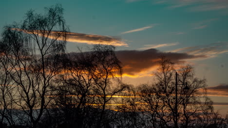 Zeitraffer-Des-Sonnenuntergangs-über-Glasgow,-Schottland,-Warme-Wolken-über-Einem-Kühlen-Himmel-Mit-Bäumen