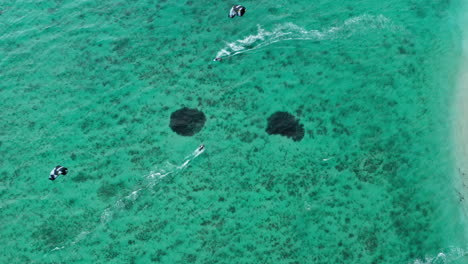 4K-Drohne-Aus-Der-Luft,-Die-Mit-Einer-Top-Down-Kamera-Von-Kitern-Aufsteigt,-Die-Durch-Erstaunlich-Blau-türkises-Wasser-Auf-Der-Tropischen-Insel-Mauritius-Surfen