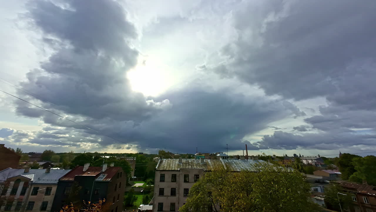 Skyer driver hurtigt over et boligområde i en by