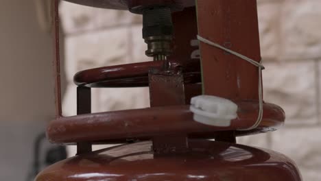 relleno de cilindros de gas de petróleo licuado a través de una válvula en una tienda minorista durante el día