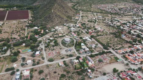 Aerial-drone-shot-of-buildings-of-cafayate-town-spread-around-foothills-of-Andean-Cordillera-Mountain-Range-in-salta-province-of-Argentina