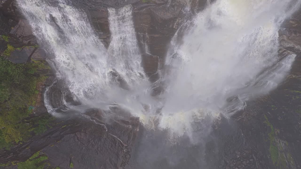 Aerial clip of Skjervefossen falling through rocky gorge on moody day