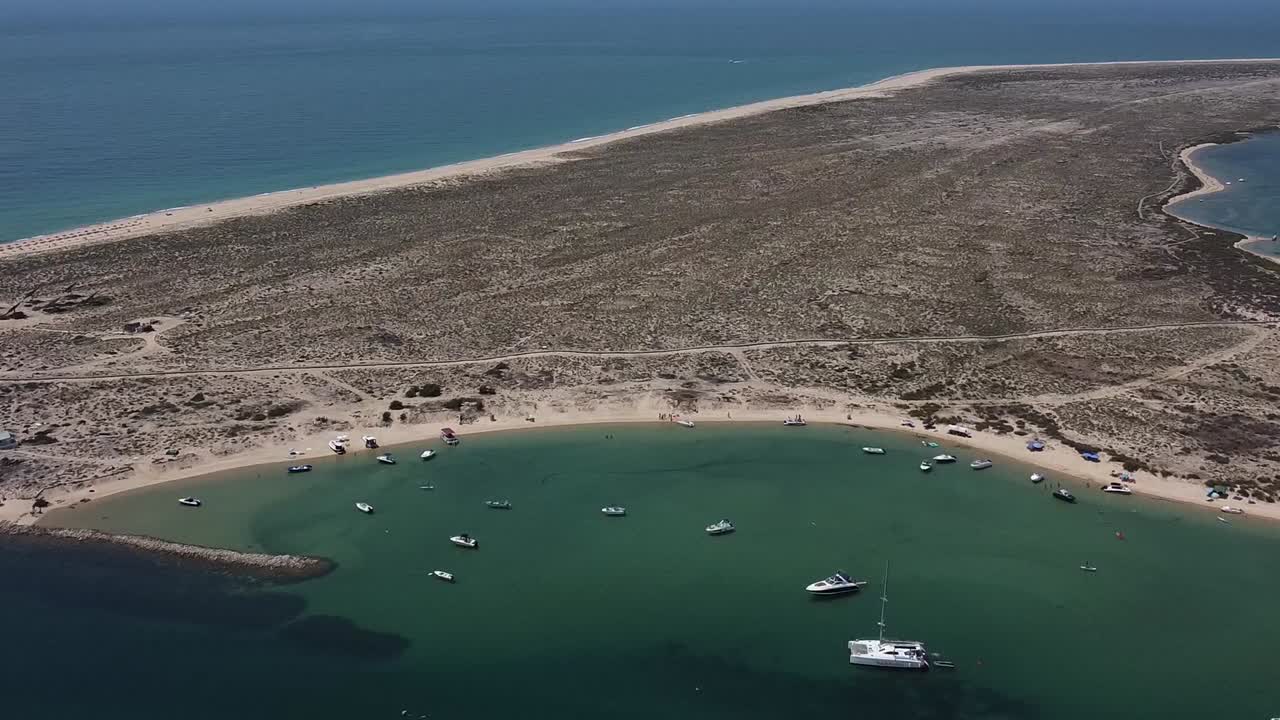 retiro aéreo de la bahía de agua de la isla desierta, agua de color esmeralda con pequeños barcos amarrados, algarve