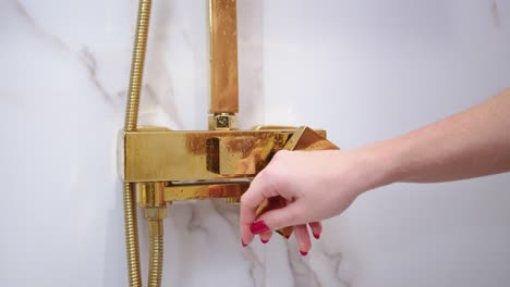 Woman-with-soft-skin-turning-on-shower-in-modern-bathroom