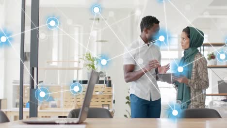 Animation of network of connections against diverse man and woman discussing at office