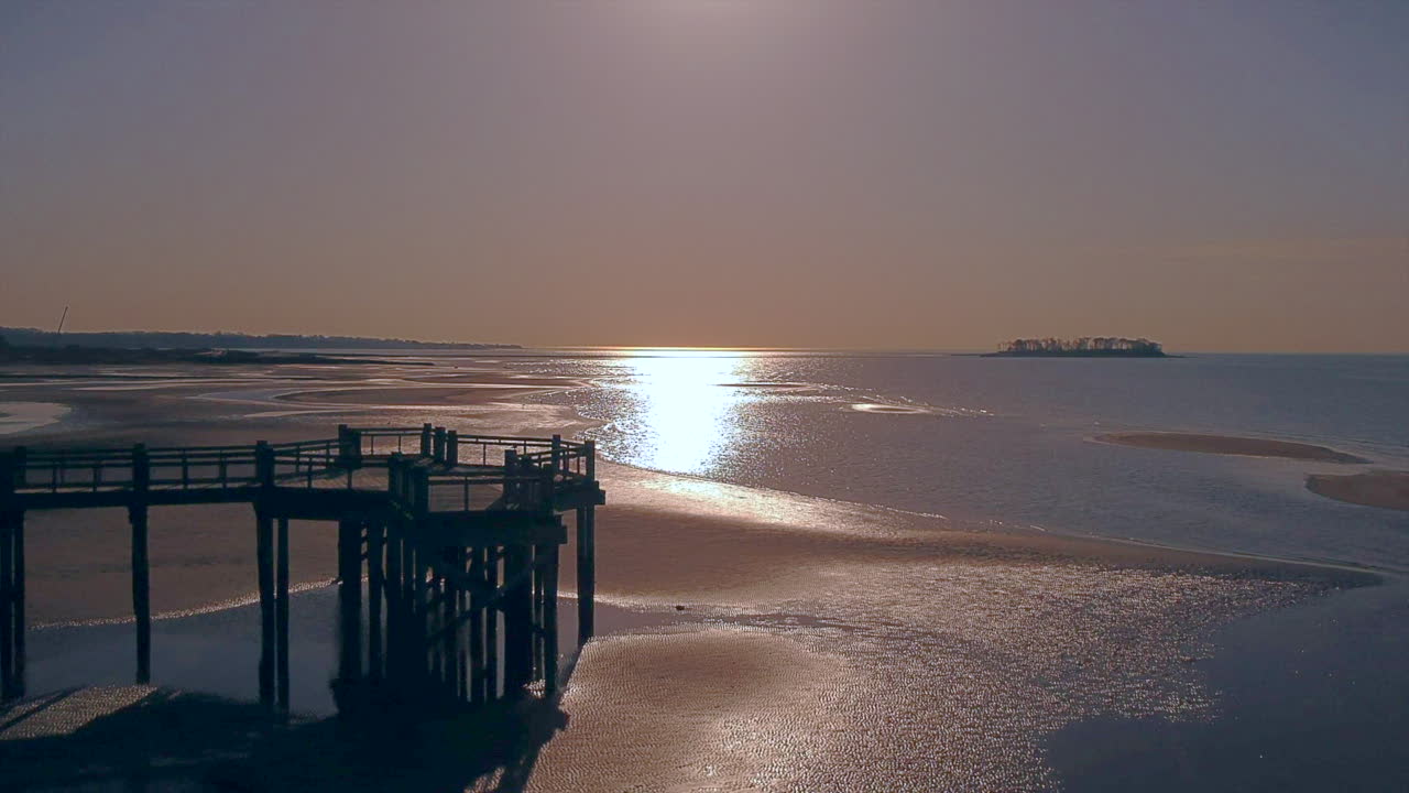 Drone flying toward the end of a pier