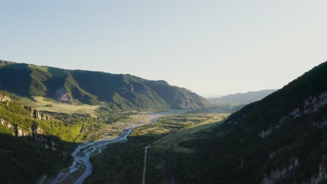 aerial view of a valley with a river and mountains