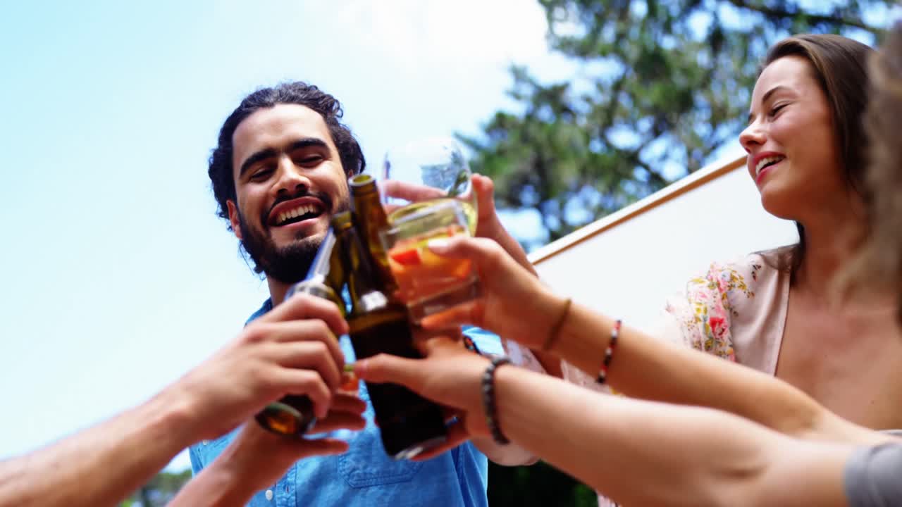 grupo de amigos felices brindando vasos de bebidas en una fiesta de barbacoa al aire libre