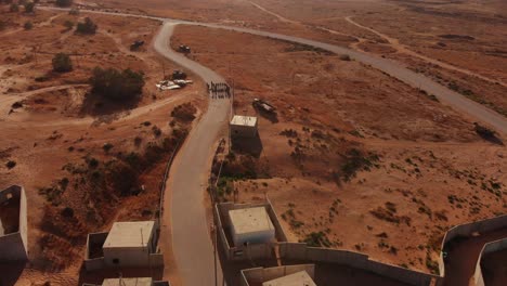 aerial shot of army troops soldiers standing in the empty road in the middle of the endless desert