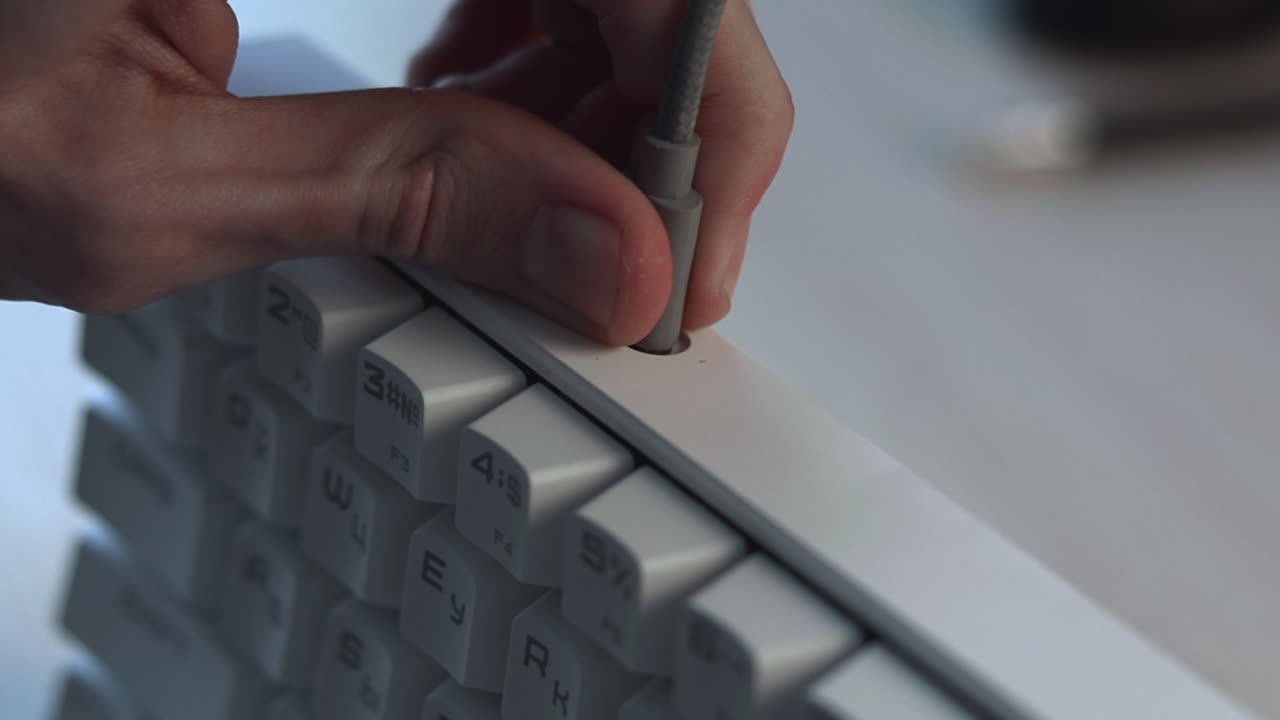 Plugging Audio Cable Into Keyboard Closeup Of IT Technicians Hands Inserting.Mm Jack Into White Mechanical