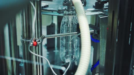 Close-up process of pouring milk into plastic bottle. Robotic machine for bottling milk in a dairy factory.