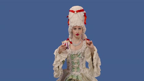 portrait of courtier lady in vintage lace dress and wig, holding fries and showing thumbs down dislike. young woman posing in studio with blue screen background. close up. slow motion ready 59.94fps