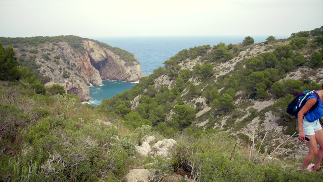 Donna che fa escursioni vicino alla costa della Costa Brava in Spagna - Area di L'Estartit nella Costa Brava, Spagna - inquadratura ampia e statica