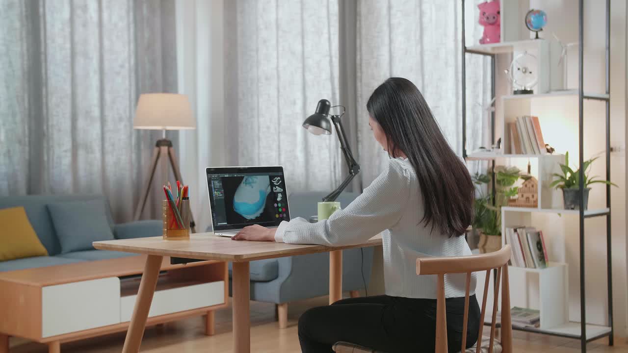 가정 사무실에서 노트북에서 신발을 디자인하는 여성.