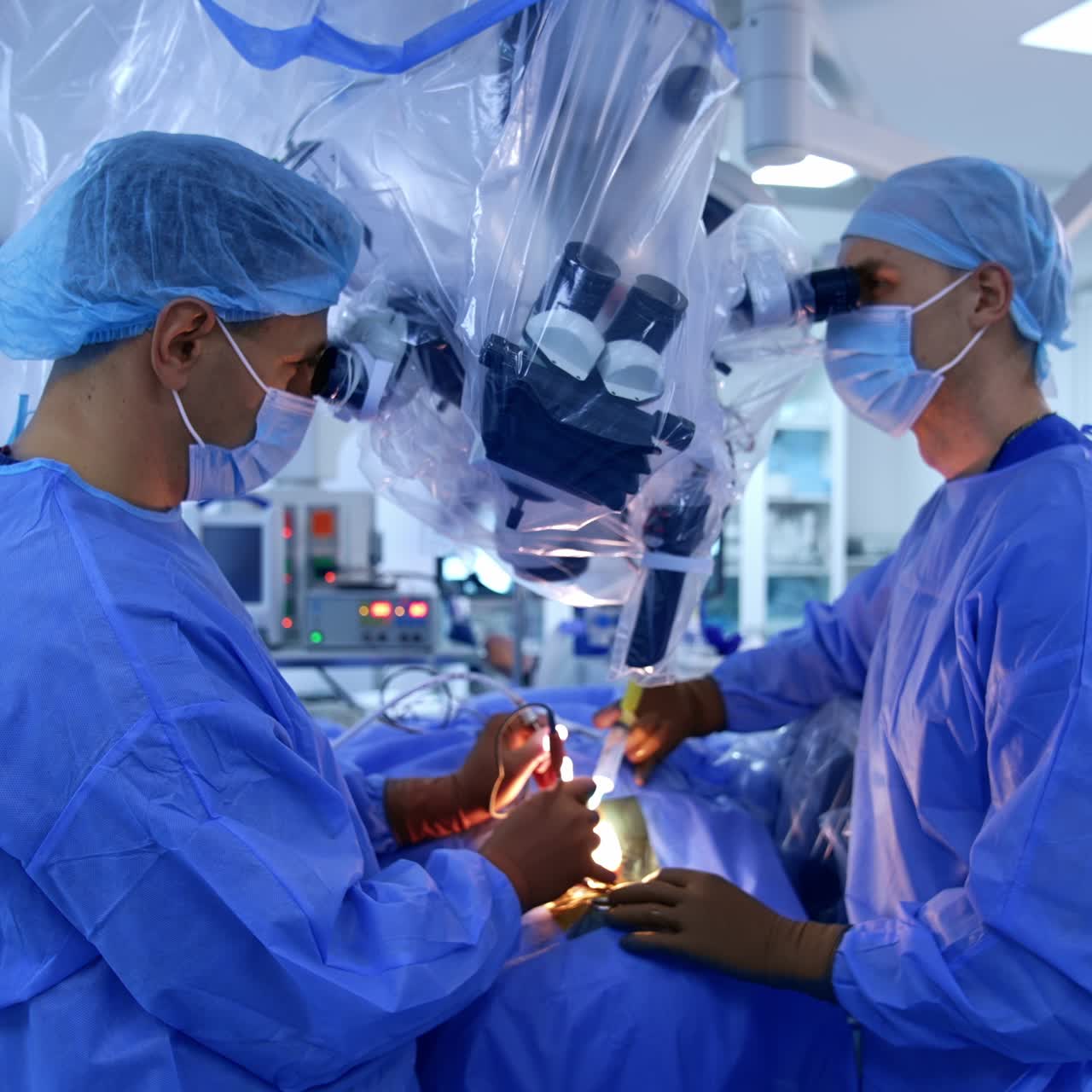 Two surgeons look at microscope performing neurosurgery. Neurological operation in modern surgery room