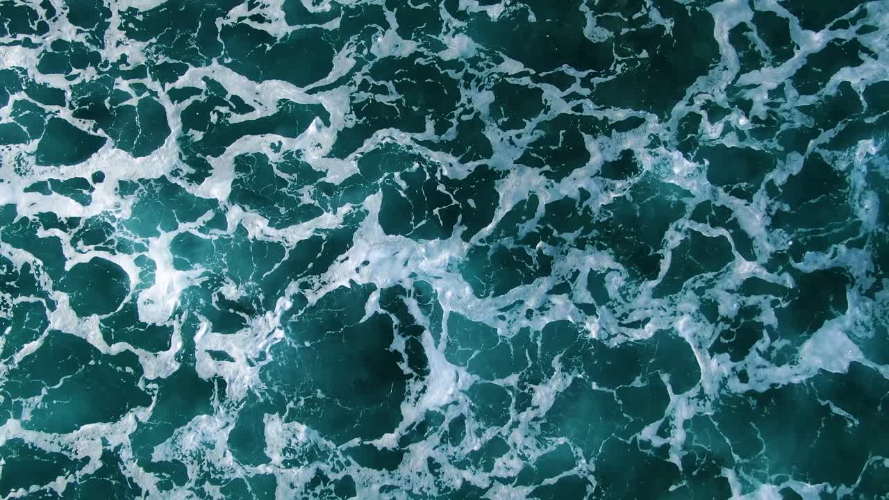 Filmato ravvicinato a volo d'uccello dell'oceano blu profondo e della risacca bianca alle Hawaii.
