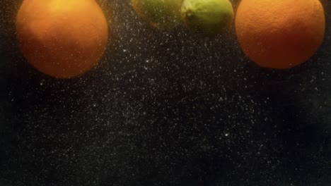 lemons and oranges falling into the water with a splash