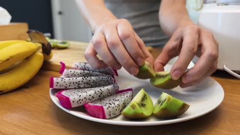 preparing a healthy fruit salad with kiwi and dragon fruit