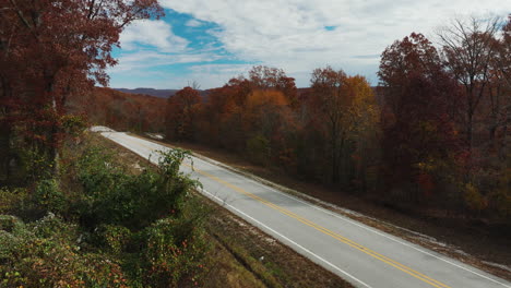 arkansas countryside road in autumn fall season, orange forest trees, tilt up