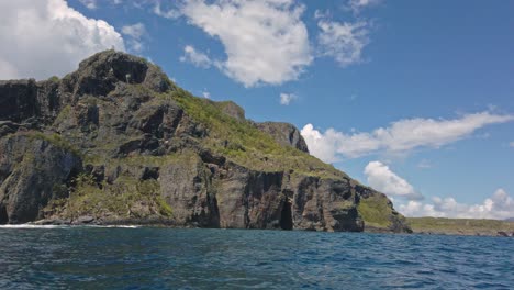 Rocky-cliff-and-cave-seen-from-boat,-Playa-Fronton-beach-in-Samana-Peninsula,-Dominican-Republic