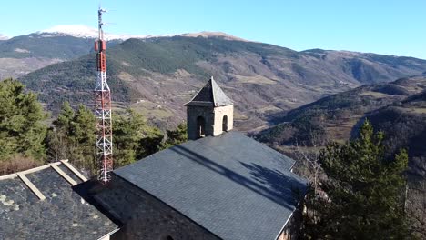 drone shot flying over a medieval church in the pyrenees mountains, spain