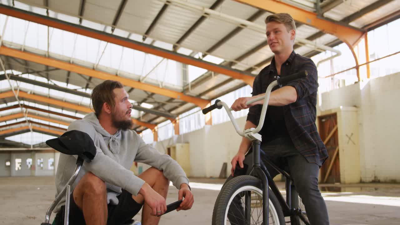 빈 창고 에서 대화 하는 bmx 라이더 들