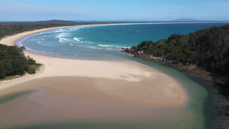 Toma-Amplia-Descendente-Del-Océano-Pacífico-Sur-Y-Korogoro-Creek-Con-Viento-Que-Sopla-Arena-A-Través-De-Una-Barra-De-Arena-En-Hat-Head-Nueva-Gales-Del-Sur,-Australia