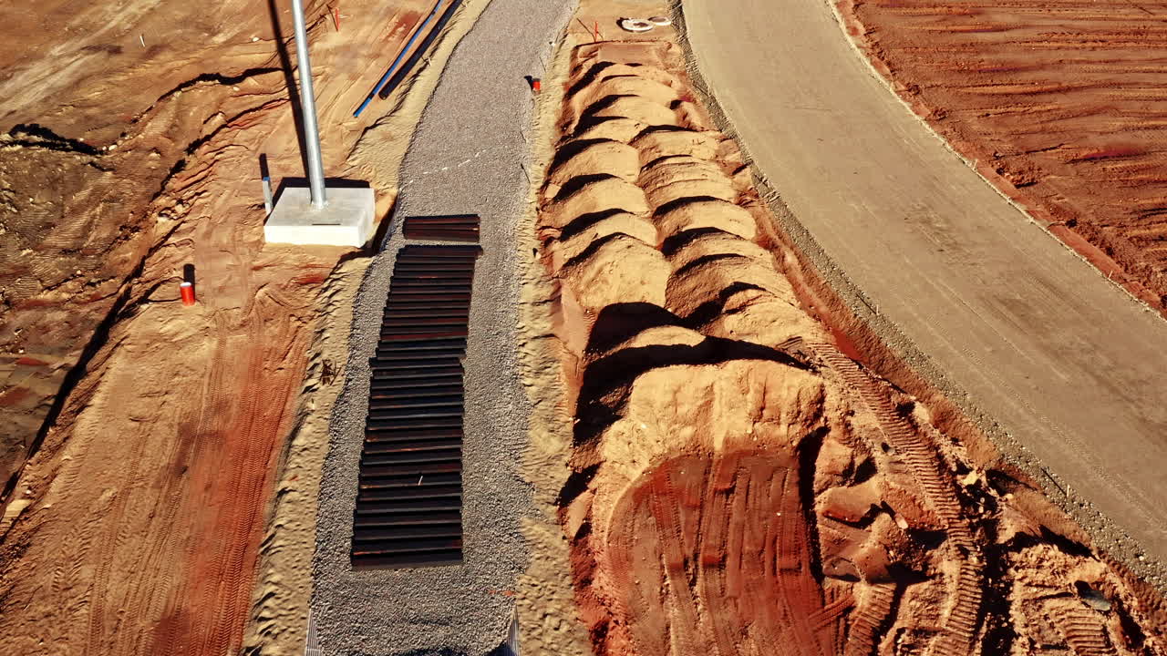 Aerial view of rail track foundation under construction in red clay terrain zone