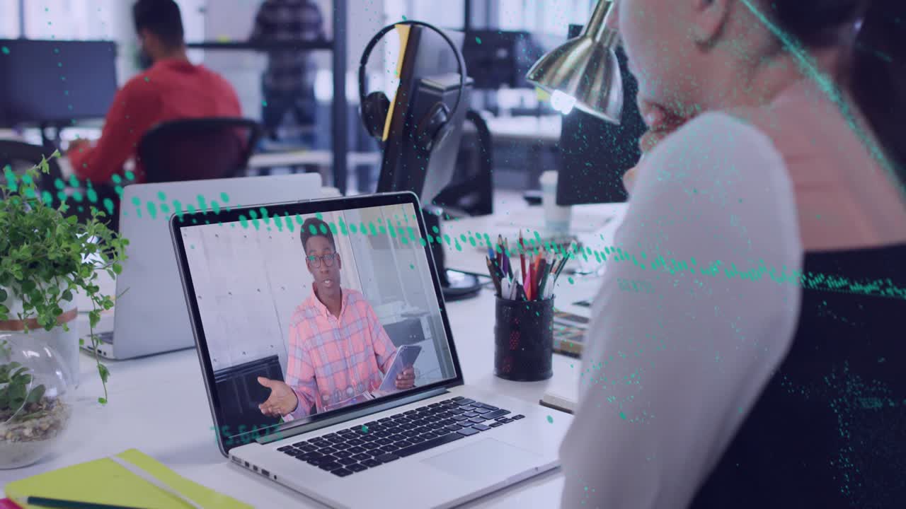 Woman watching while man on laptop tapping tablet causing green overlay sweeping across business
