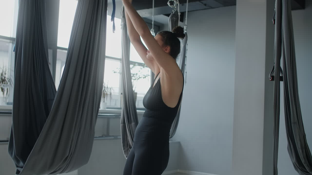 mujer practicando yoga aéreo