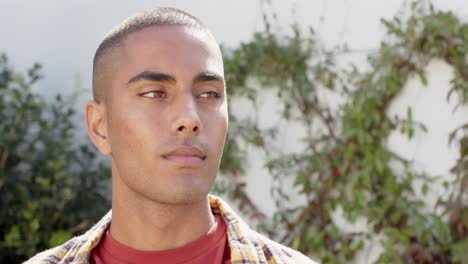 portrait of biracial man in sunny garden, slow motion