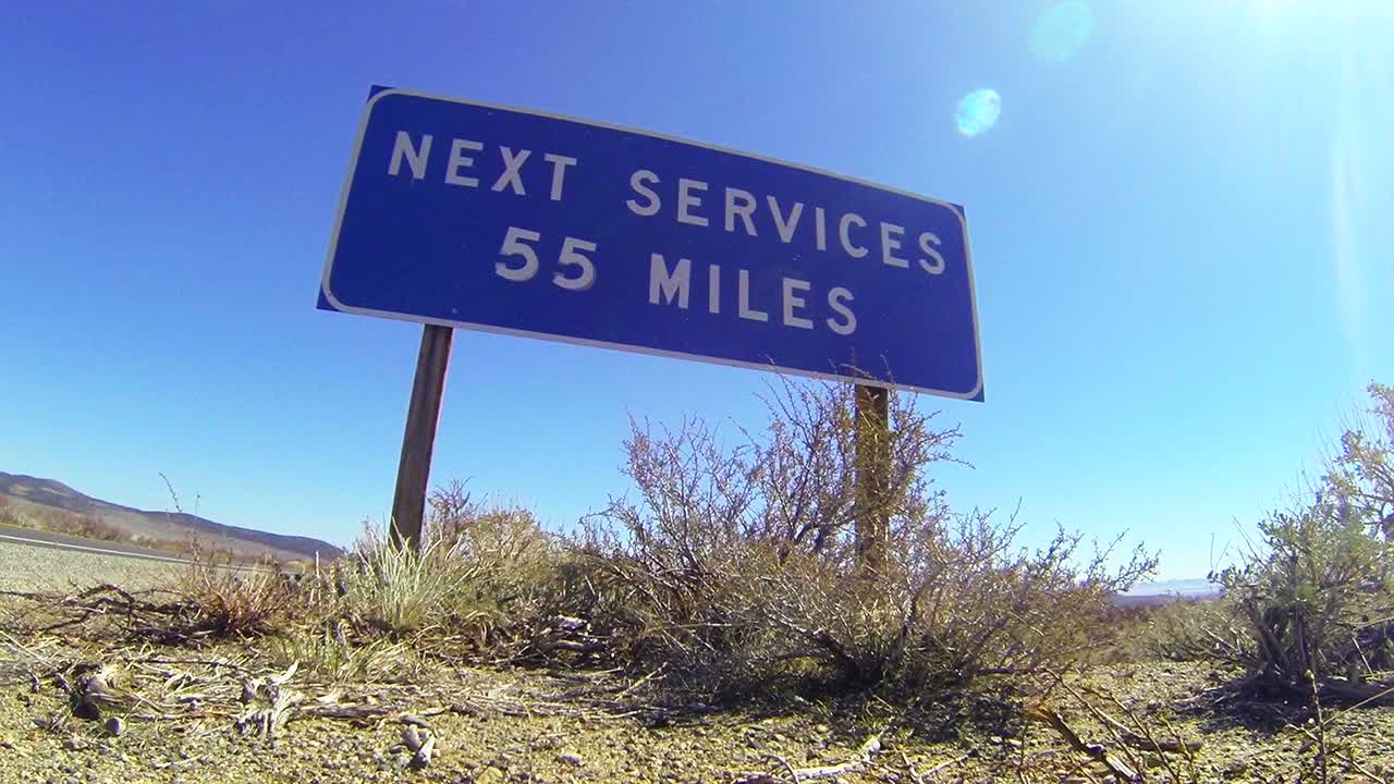 외로운 사막 도로의 표지판은 다음 서비스가 55마일 떨어져 있음을 경고합니다.