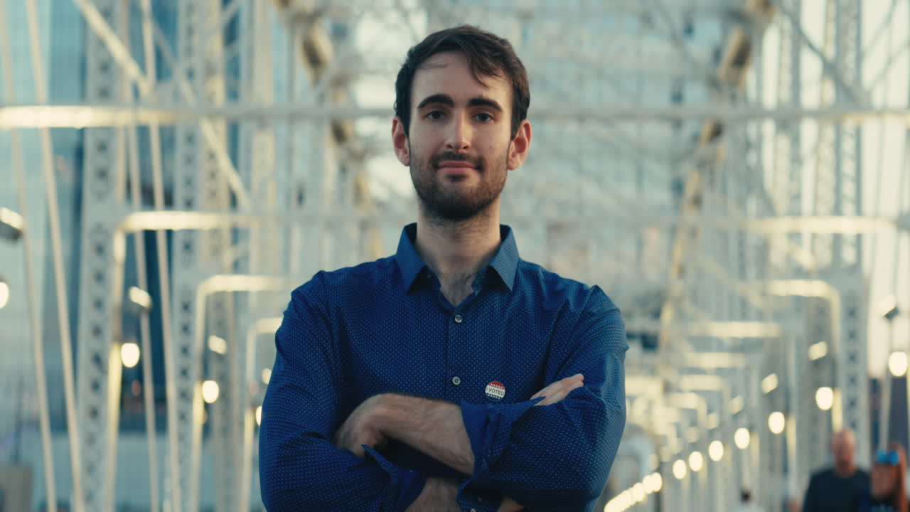 Portrait of a man wearing an I Voted sticker on a bridge