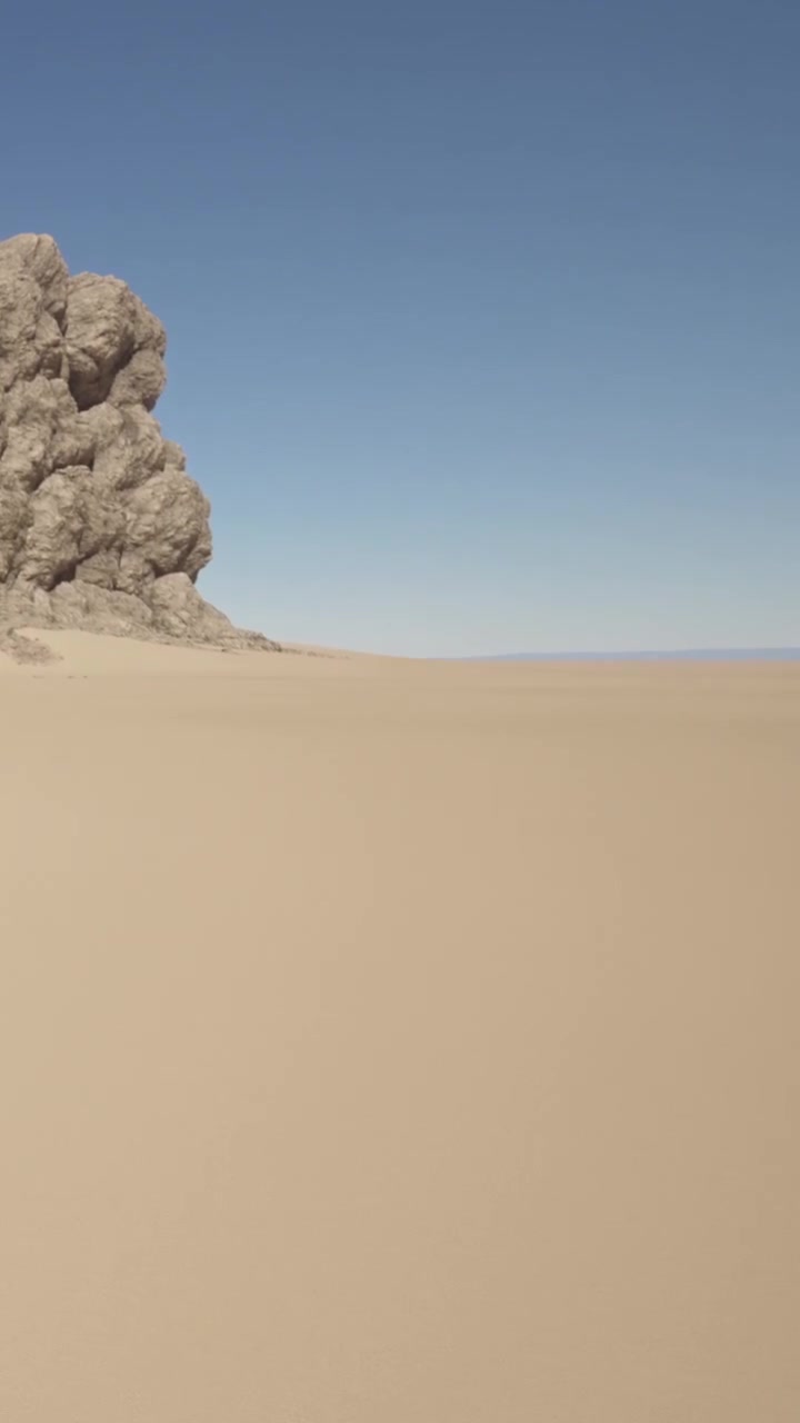 Felsformation nahe einer weiten Sandfläche unter klarem Himmel tagsüber