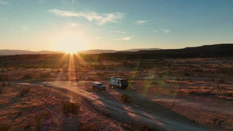 car and travel trailer parked at the campsite during sunset