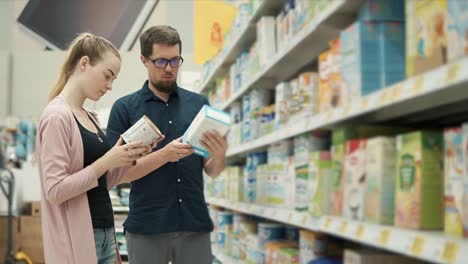pareja comprando comida para bebés en la tienda de comestibles