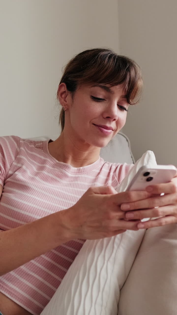 mujer relajándose en el sofá usando un teléfono inteligente