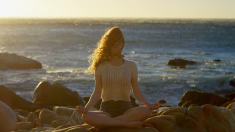 mujer realizando yoga en la playa 4k