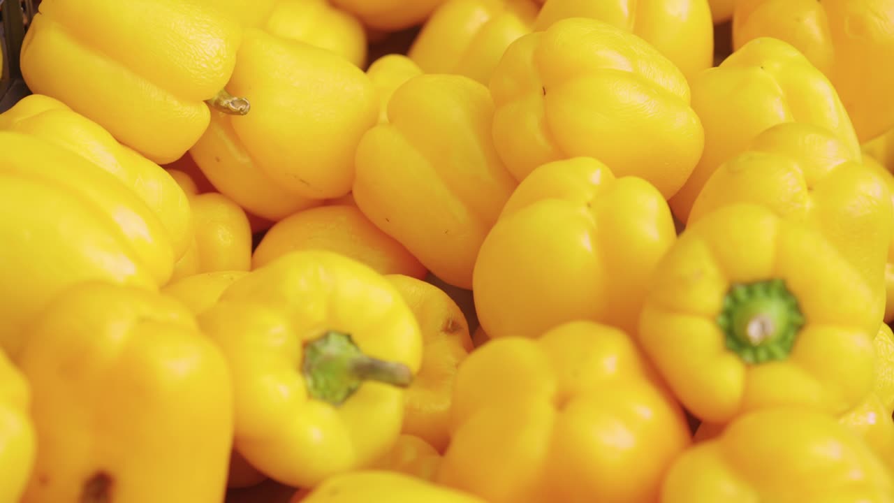 Green, Yellow, and Red Bell Peppers for sale at a farmers market closeup