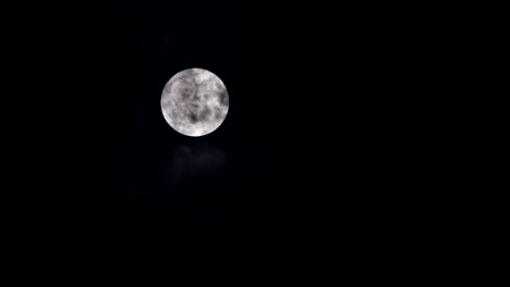 luna llena sobre el cielo oscuro con una noche misteriosa nublada
