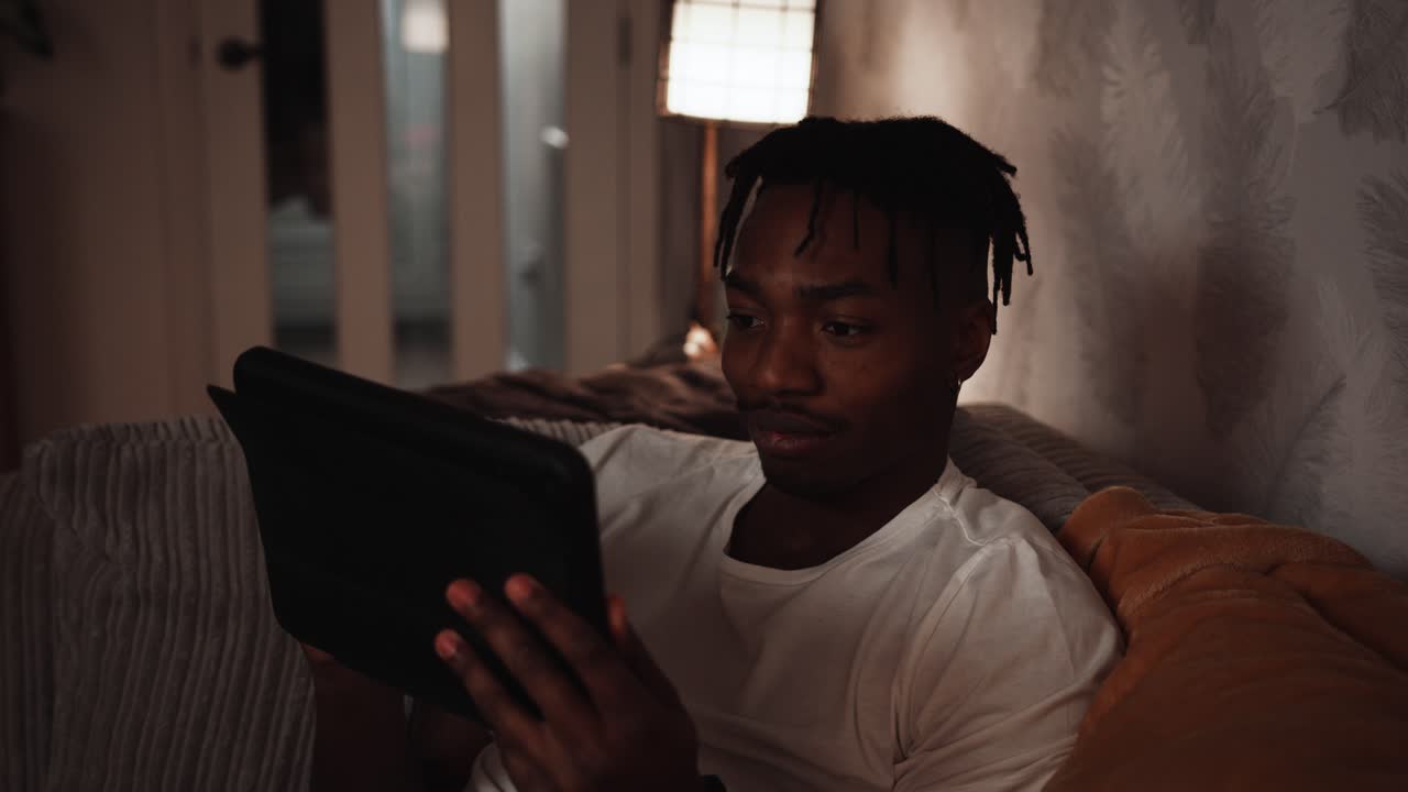 Young black male selects something to watch on his tablet device