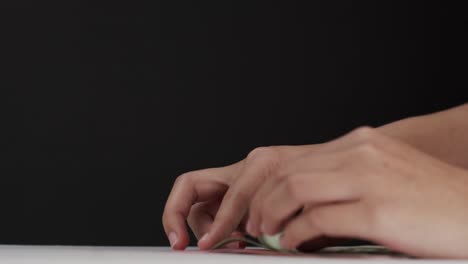 holding banknotes one by one using hands and fingers.