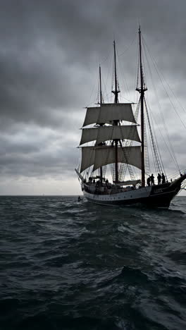 a tall ship at sea in a stormy sky