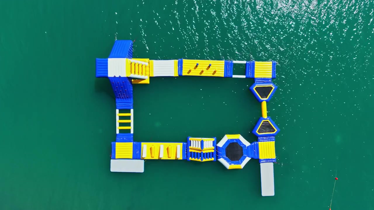 Colorful water activity area sits on the surface of the clear water, inviting visitors to enjoy fun and exercise during a sunny day