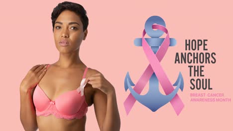 animation of pink ribbon anchor logo with breast cancer text over smiling woman in pink bra