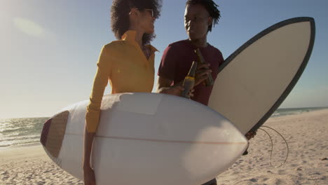 couple walking together with surfboard on the beach 4k