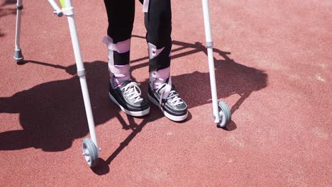 a young child is using a walker to help them walk after breaking their leg.