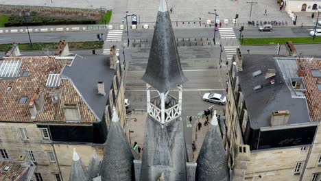 Bordeaux-city-gate-at-Porte-Cailhau-overlooking-the-Garonne-river-in-France,-Aerial-dolly-out-reveal-shot