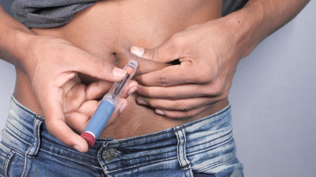 남자가 복부에 인린을 주사하고 있습니다.